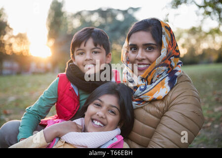 Portrait happy Muslim mother in hijab with children in autumn park Stock Photo