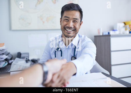Point of view happy doctor shaking hands with patient Stock Photo