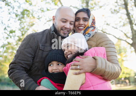 Portrait happy Muslim family hugging in autumn park Stock Photo