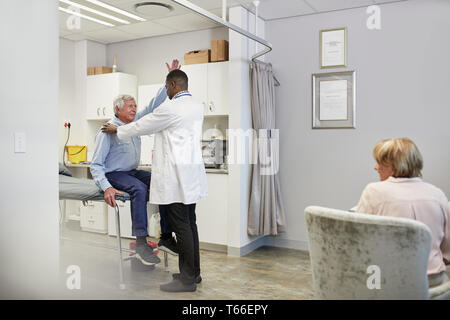 Doctor examining senior male patient in examination room Stock Photo