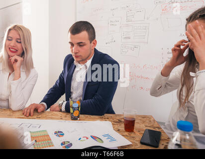 Handsome businessman with his two female architects smiling and discussing a project. Stock Photo