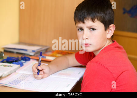 tired and bored boy doing school homework Stock Photo