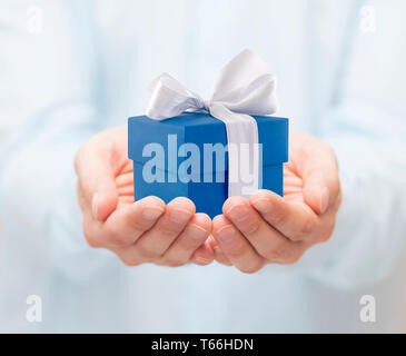 Small blue present box in hands Stock Photo