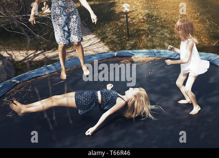 Happy family jumping on trampoline Stock Photo