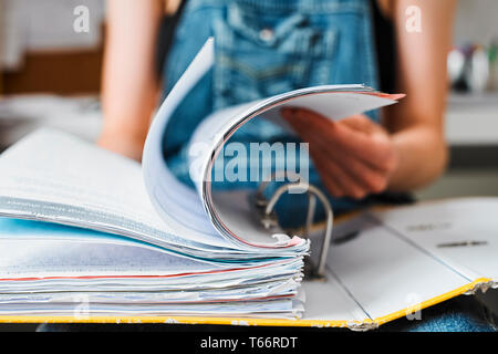 Female college student studying, looking through binder Stock Photo