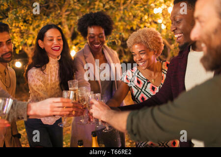 Happy friends celebrating, toasting champagne at dinner garden party Stock Photo