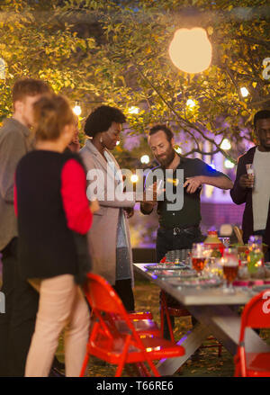 Friends celebrating with champagne at dinner garden party Stock Photo