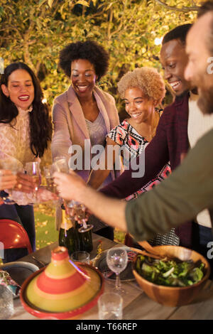 Friends celebrating, toasting champagne at dinner garden party Stock Photo