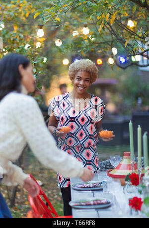 Happy women friends setting table for dinner garden party Stock Photo