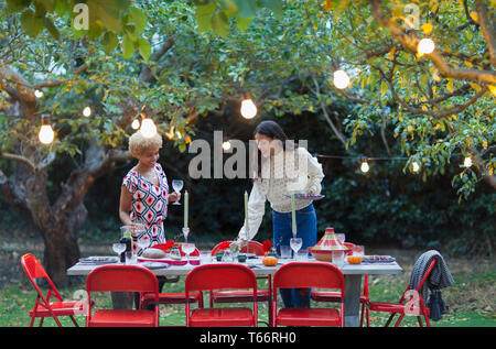 Women friends setting table for dinner garden party Stock Photo