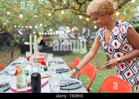Woman setting table for dinner garden party Stock Photo