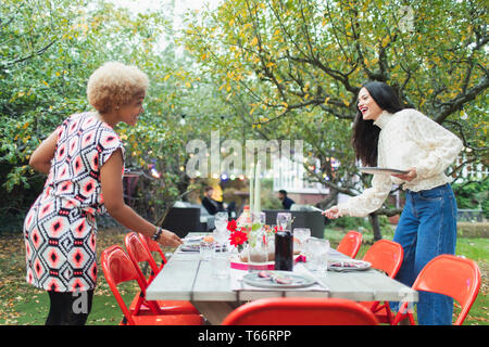 Women friends preparing table for dinner garden party Stock Photo