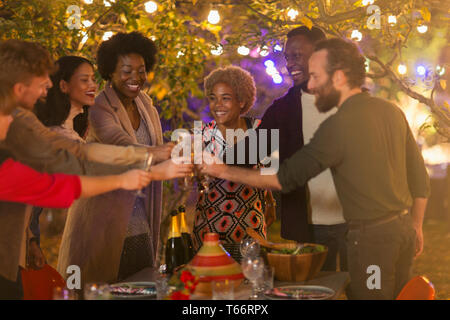 Happy friends toasting wine glasses at dinner garden party Stock Photo