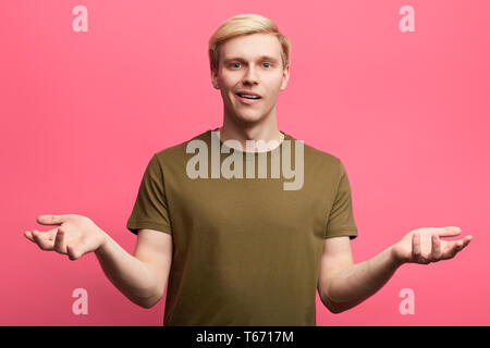 doubtful puzzled man with shocked expression. close up photo. isolated pink background. misunderstanding concept Stock Photo