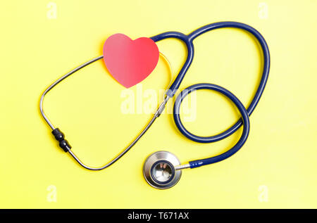 Stethoscope and red heart shape sticker on yellow background. Healthcare check  concept Stock Photo