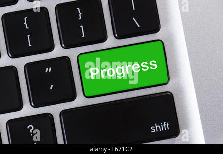 Development growth process of improvement to achieve goal. Text Progress on green button of computer keyboard Stock Photo