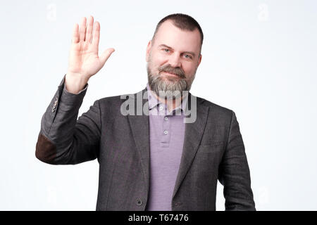 Mature man in jacket wave hand welcome. Stock Photo