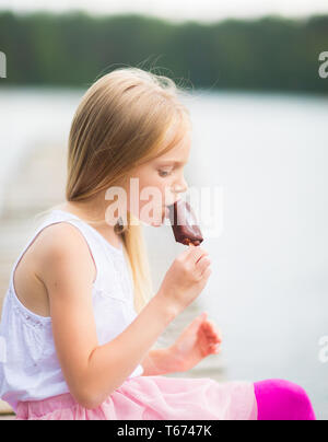 Little girl eats stick ice cream bar eskimo pie Stock Photo