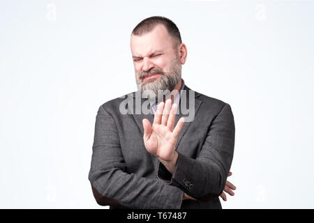 Handsome mature man with beard making stop sign Stock Photo