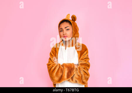 Young woman in bunny kigurumi standing isolated on pink background crossed arms looking camera sassy Stock Photo