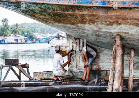 closeup of man with hammer working on keel of a  hull of a boat Stock Photo