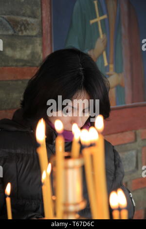 Beautiful young woman praying in church Stock Photo