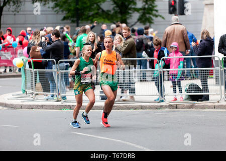 Louzanne Coetzee with her guide runner, competing in the 2019 London Marathon. Louzanne went on to finish 9th in the T11/12 Category, in a time of 03:33:22. Stock Photo