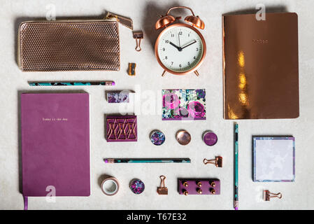 Notebooks for writing Dreams and Ideas, with different gold and maroon Stationery laying on grey background. Top View. Idea of Girly Office settings.  Stock Photo