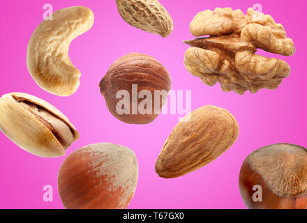 Falling nuts on color background Stock Photo