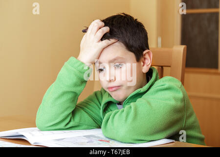 bored and tired boy doing homework Stock Photo