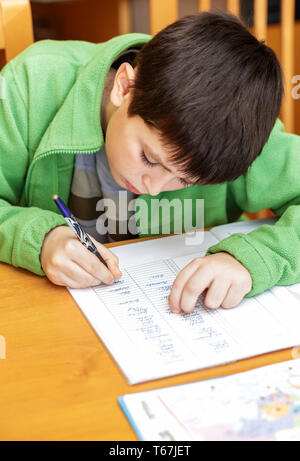 bored and tired boy doing homework Stock Photo