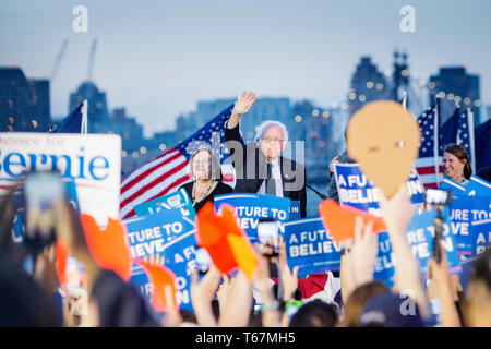 On the eve before the New York State primaries election in 2016, Presidential hopeful Senator Bernie Sanders (D-Vt) holds a last rally in the Hunters Point South Park in Queens. His campaign slogan 'A future to believe in' is on all the posters, and with the Manhattan skyline as a backdrop with the Empire State Building clearly visible. Stock Photo