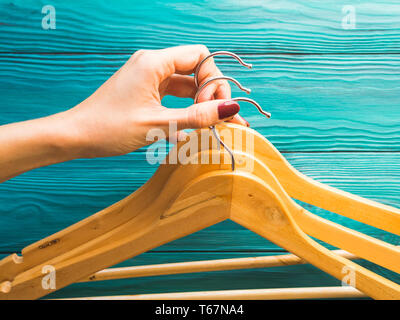 Wooden hangers with no clothes on green wooden background. Clothing storage, sale shopping concept Stock Photo