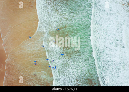 Surfing Aerial. Beach on aerial drone top view with ocean waves reaching shore. Top view aerial photo from flying drone of an amazingly beautiful sea  Stock Photo