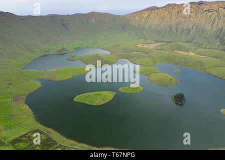 Aerial view of volcanic crater (Caldeirao) with a beautiful lake on the top of Corvo island. Azores islands, Portugal. Stock Photo