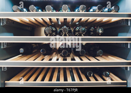 Storing bottles of wine in fridge. Alcoholic card in restaurant. Cooling and preserving wine. Stock Photo