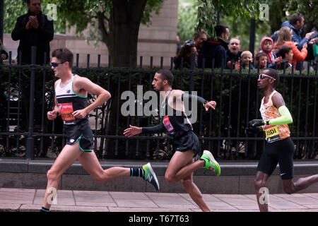 Callum Hawkins (GBR), Yassine Rachik (ITA) and Bashir Abdi (BEL), battling it out around Canary Wharf, during the 2019 London Marathon. They went on to finish 10th, 9th and 7th respectively  in the Men's elite race. Stock Photo