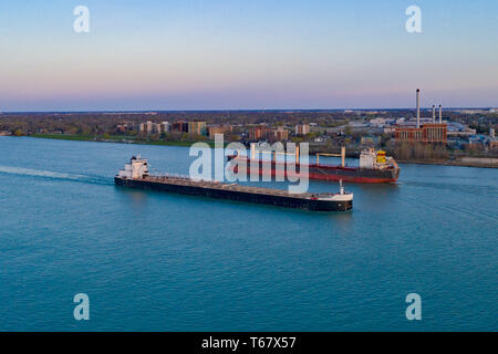Detroit, Michigan - Great Lakes freighters on the Detroit River. The American Mariner (foreground) , a self-unloading bulk cargo carrier, steams downr Stock Photo