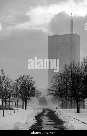 Clean road during a Snowy night with building in a mist. Belgrade, Serbia, Europe. Black and white image Stock Photo