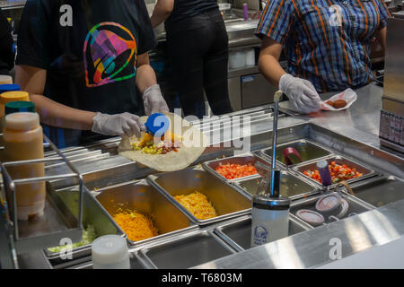 Workers prepare food in the Taco Bell Cantina restaurant in Midtown Manhattan in New York on Tuesday, April 23, 2019 during one of their 600 Hiring Parties they are hosting. The restaurant chain is intent on filling thousands of open position across the country before the summer and is offering candidates on-the-spot interviews, not to mention free food at the events. Prospective employees can also apply online if unable to attend a Hiring Party.  (Â© Richard B. Levine) Stock Photo