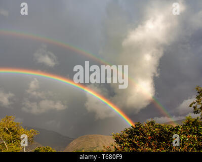 Landscape with two rainbows on a stormy sky. Captured at the Andean mountains of central Colombia. Stock Photo