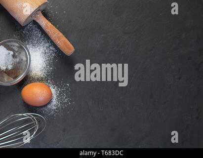 egg and flour on dark background top view Stock Photo