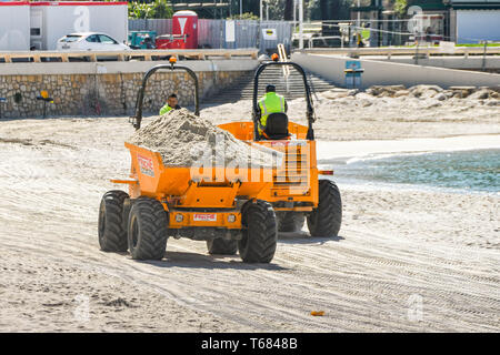 CANNES, FRANCE - APRIL 2019: Dumper trucks transporting sand across the beach in Cannes ready for the spring and summer holiday season Stock Photo