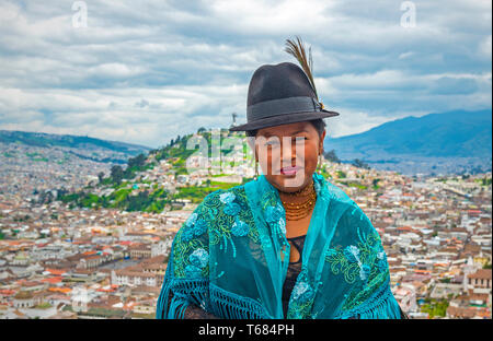 Portrait of a smiling indigenous Otavalo woman in front of the historic city center of Quito in the Andes mountain range, Ecuador. Stock Photo