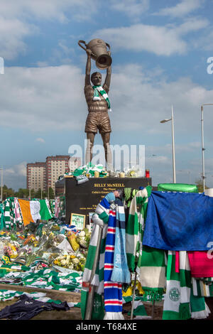 GLASGOW, SCOTLAND - 29th APRIL 2019:  The statue of the Celtic icon, Billy McNeill, surrounded by scarves and shirts. Including a Manchester city and  Stock Photo