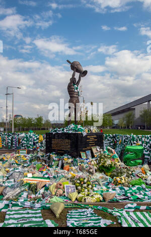 GLASGOW, SCOTLAND - 29th APRIL 2019:  The statue of the Celtic icon, Billy McNeill, surrounded by scarves and shirts. Stock Photo