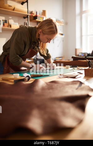 Female Artisan Working in Sunlit Shop Stock Photo