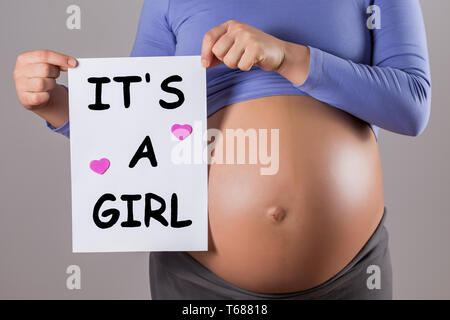 Image of close up stomach of pregnant woman holding paper with text it s a girl on gray background Stock Photo Alamy