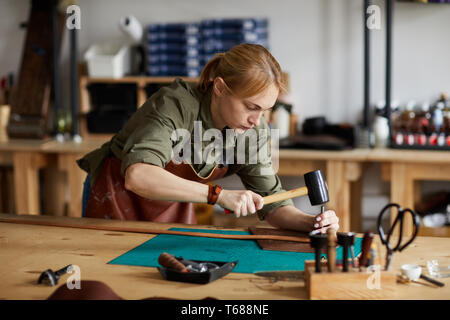 Female Craftsman Working in Shop Stock Photo