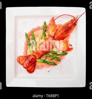 Prepared lobster on porcelain plate, isolated over black Stock Photo